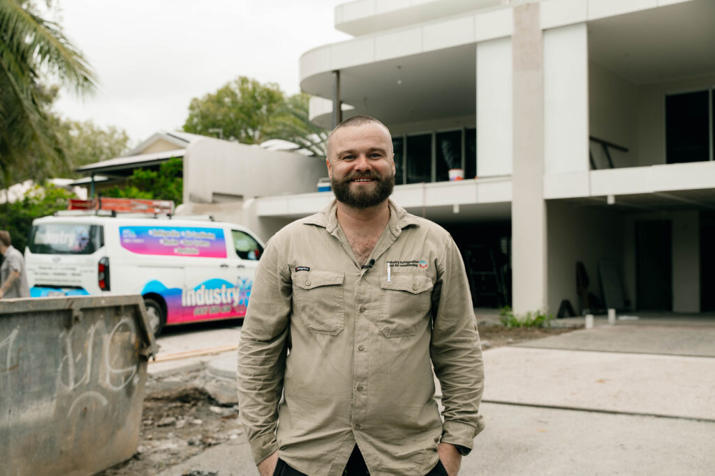 Industry Refrigeration technician on site at a residential job with a service van behind