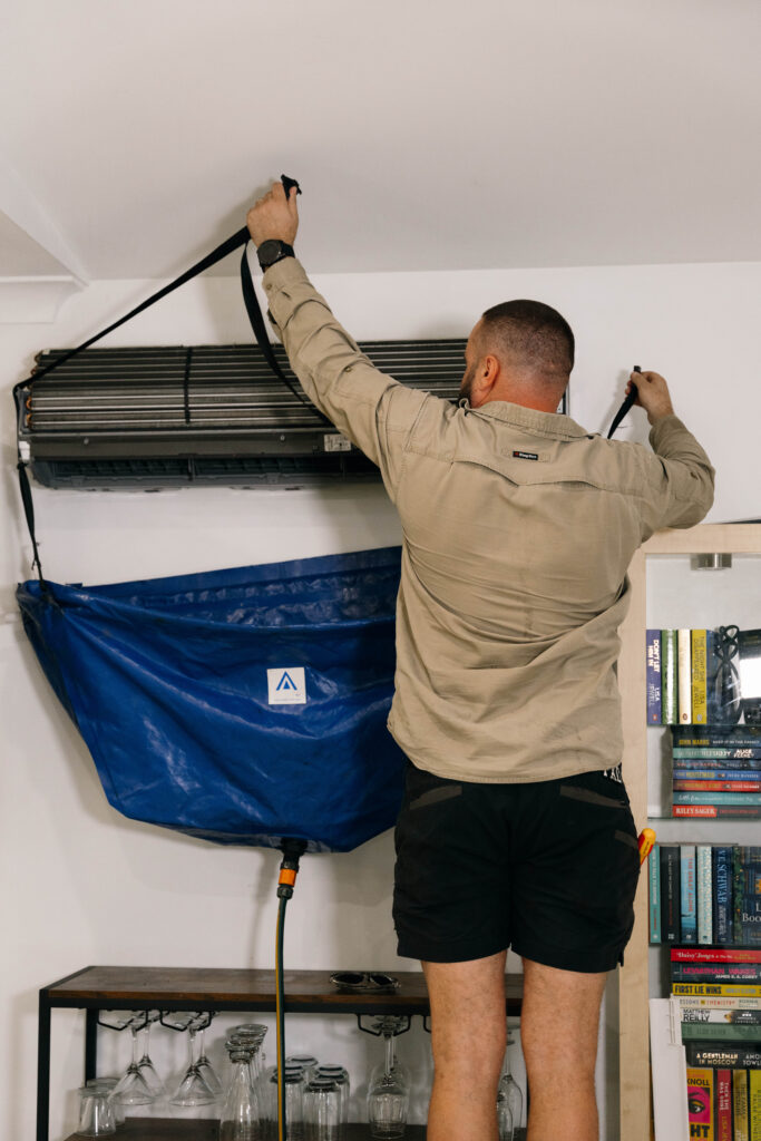 Technician fitting insulated strip curtains at a commercial coolroom doorway